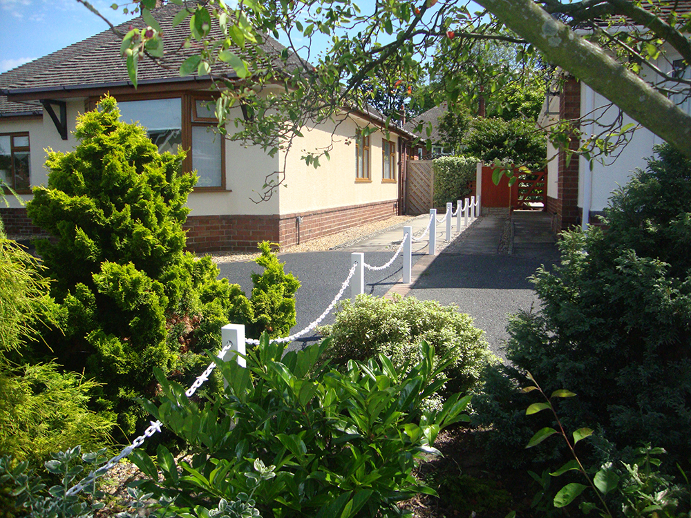 White Fence Post With White Chain Driveway